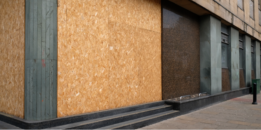 Buildings with the windows boarded up.